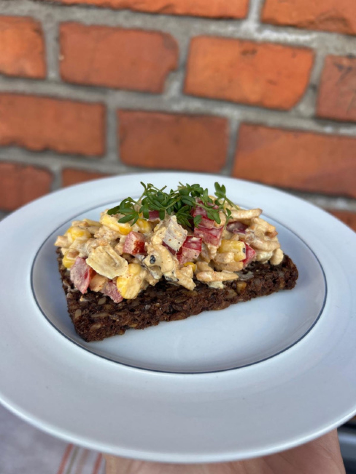 A pale-yellow curry salad with sweetcorn, red pepper cubes, red onion and Sloppy Jo's Basic Filling, plated on a board